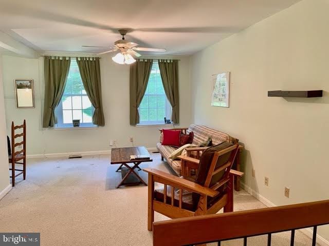 sitting room with baseboards, ceiling fan, and carpet floors