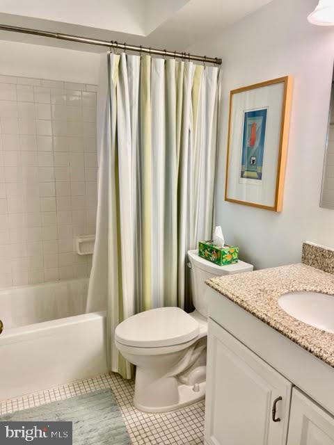 bathroom featuring tile patterned flooring, shower / tub combo with curtain, toilet, and vanity