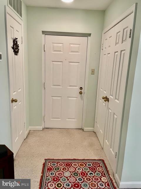 doorway featuring baseboards and visible vents