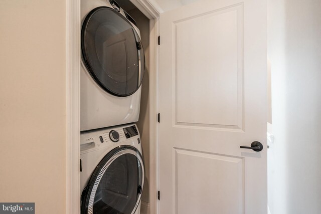 laundry area featuring stacked washer / drying machine and laundry area
