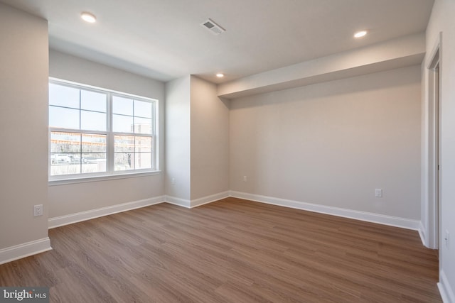 spare room with recessed lighting, wood finished floors, and visible vents