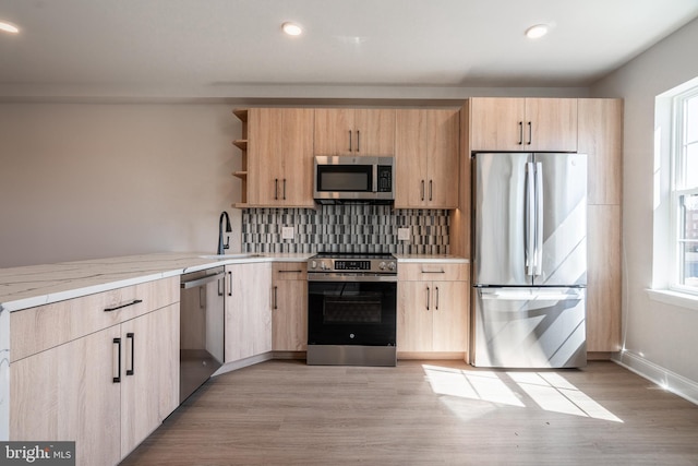 kitchen featuring open shelves, light brown cabinets, a sink, and appliances with stainless steel finishes