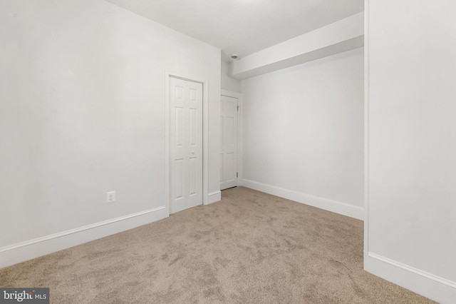 spare room featuring baseboards and carpet flooring