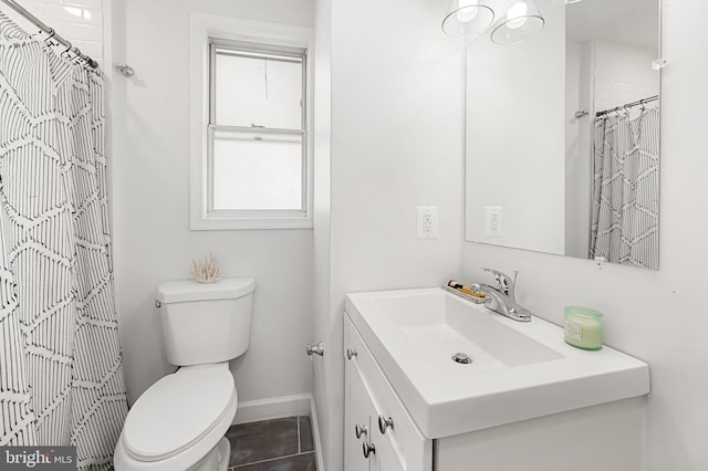 bathroom with a healthy amount of sunlight, toilet, vanity, and baseboards