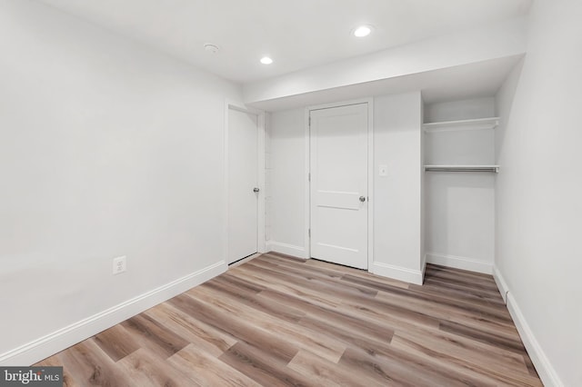 unfurnished bedroom with a closet, light wood-style flooring, recessed lighting, and baseboards