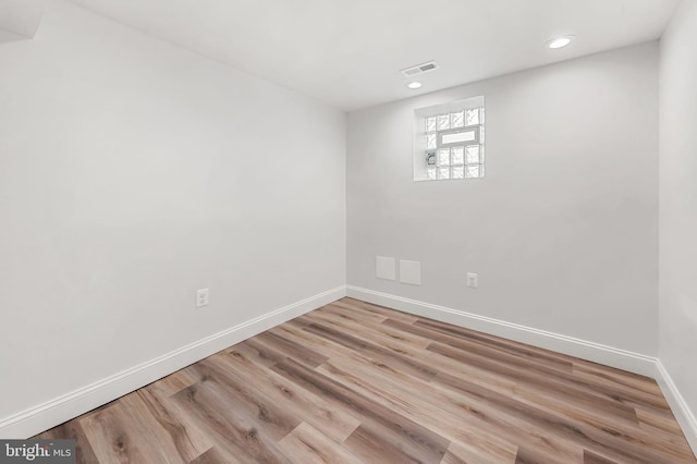 empty room with baseboards, visible vents, wood finished floors, and recessed lighting