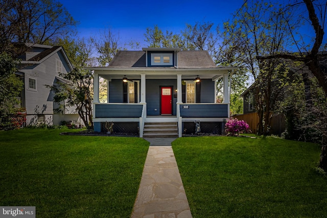 bungalow featuring a porch, ceiling fan, and a front lawn
