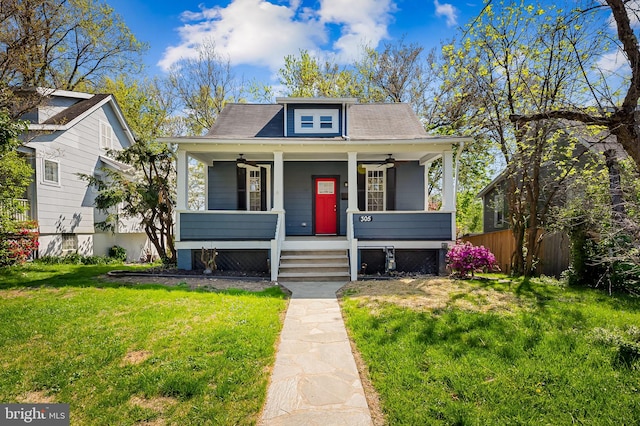 bungalow-style home featuring fence, a ceiling fan, a porch, and a front lawn