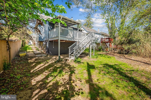 back of house with fence, a deck, and stairs