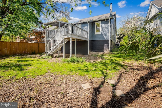 back of house with a deck, stairway, fence, and a chimney