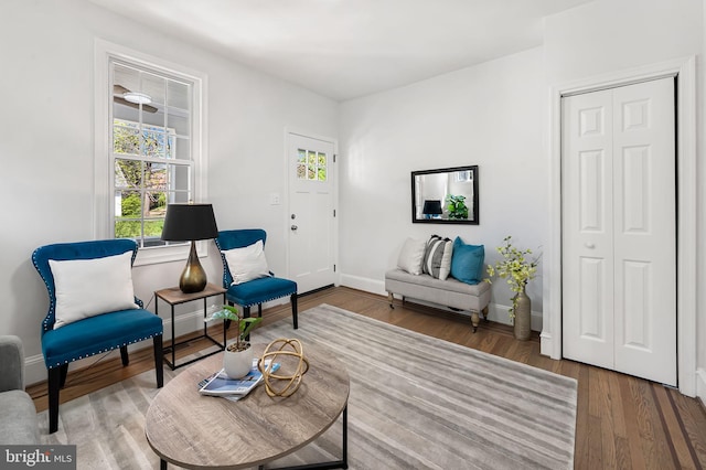 sitting room featuring baseboards, wood finished floors, and plenty of natural light