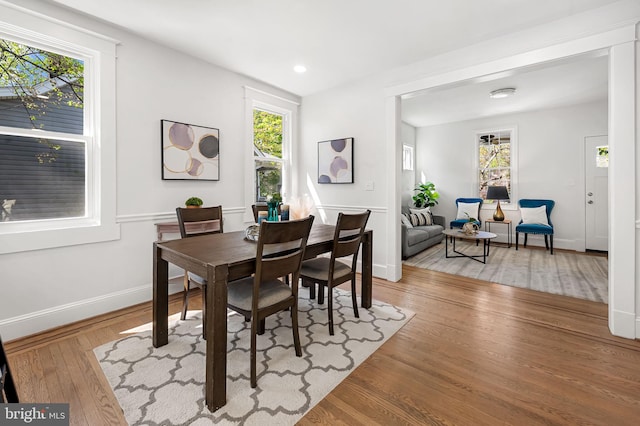 dining room featuring wood finished floors, recessed lighting, and baseboards