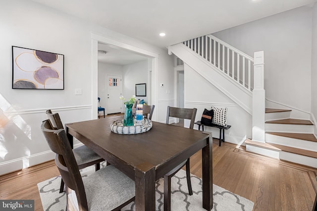 dining area with light wood-style floors, recessed lighting, baseboards, and stairs