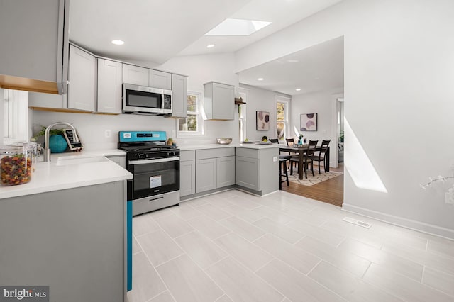 kitchen featuring recessed lighting, gray cabinets, stainless steel appliances, and light countertops