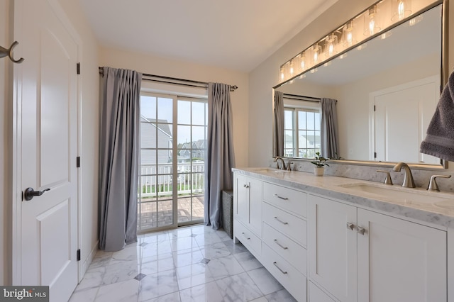 bathroom with plenty of natural light, marble finish floor, and a sink