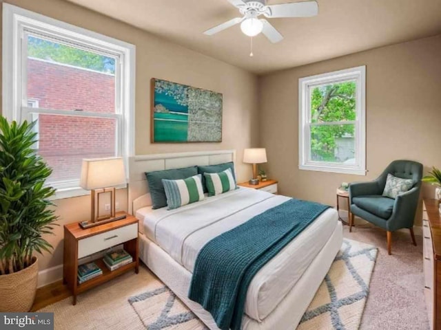 bedroom with a ceiling fan, multiple windows, and baseboards