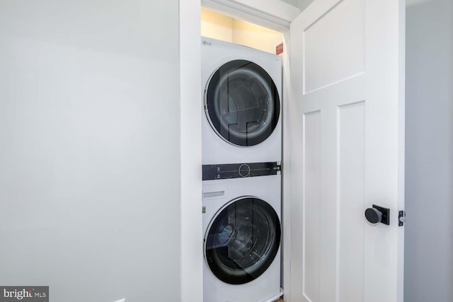 washroom with stacked washer / drying machine and laundry area