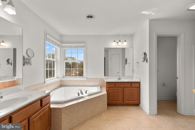 full bathroom with tile patterned flooring, a bath, visible vents, and a sink