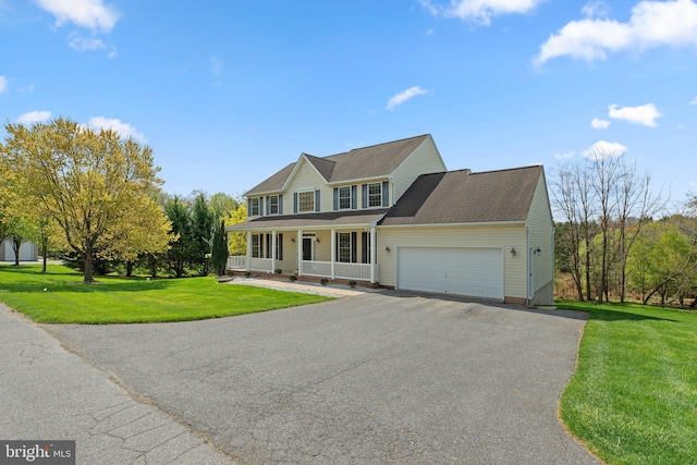 colonial-style house with an attached garage, driveway, a porch, and a front yard