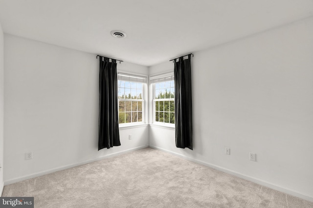 empty room with baseboards, carpet flooring, and visible vents