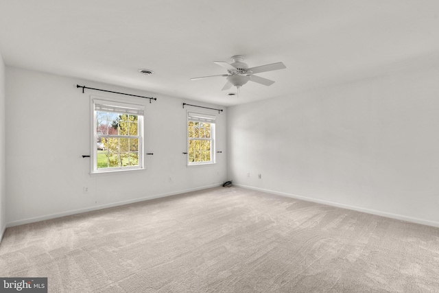 unfurnished room with carpet, visible vents, baseboards, and ceiling fan
