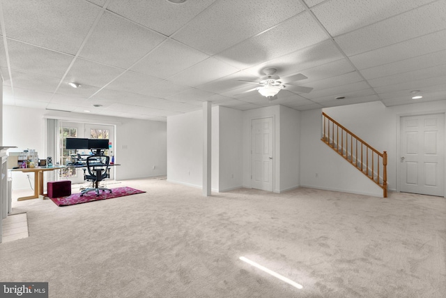 interior space featuring ceiling fan, a paneled ceiling, carpet floors, and stairway