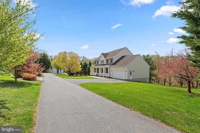 view of front facade with a garage, driveway, and a front lawn