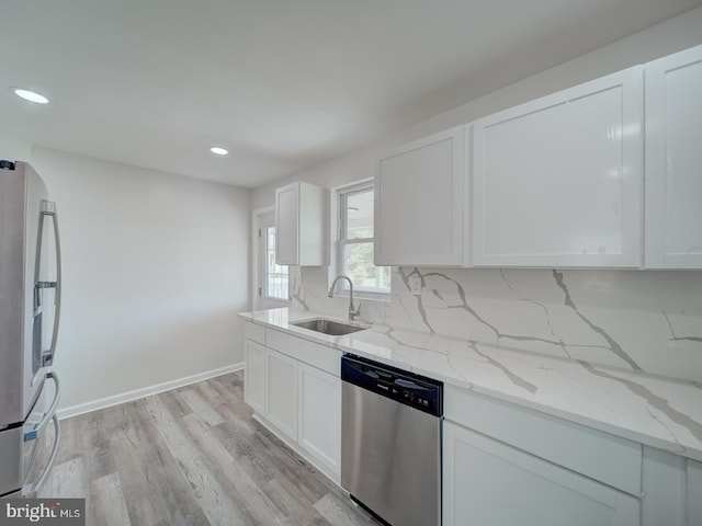 kitchen featuring light stone countertops, a sink, recessed lighting, and appliances with stainless steel finishes