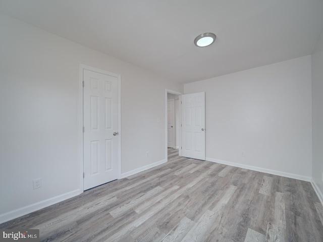 unfurnished bedroom featuring wood finished floors and baseboards