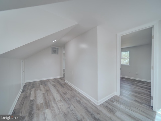 bonus room featuring lofted ceiling, wood finished floors, and baseboards