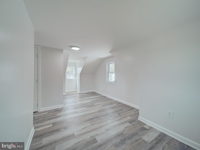 bonus room featuring lofted ceiling, baseboards, and wood finished floors