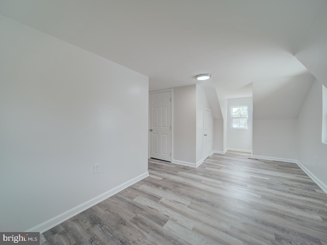 bonus room with light wood-style flooring and baseboards
