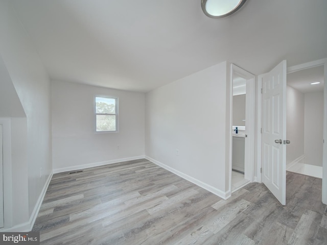 interior space with baseboards, visible vents, and light wood-style flooring