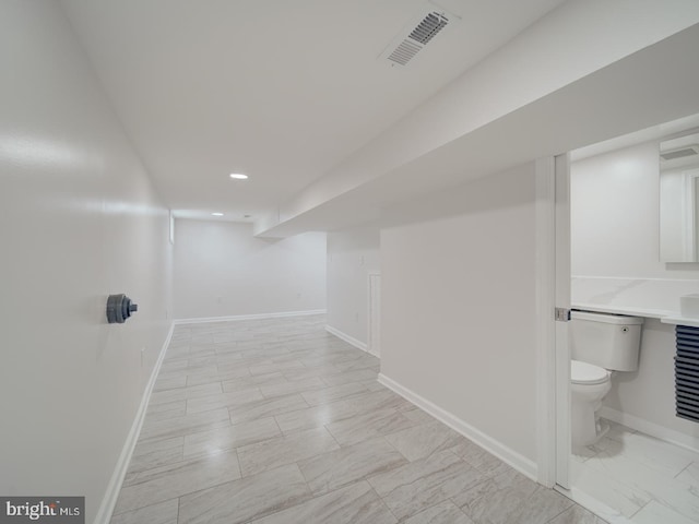 interior space featuring toilet, baseboards, visible vents, recessed lighting, and marble finish floor