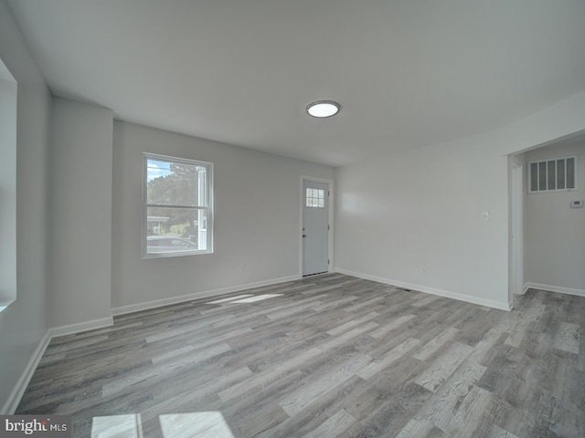interior space featuring baseboards, wood finished floors, and visible vents