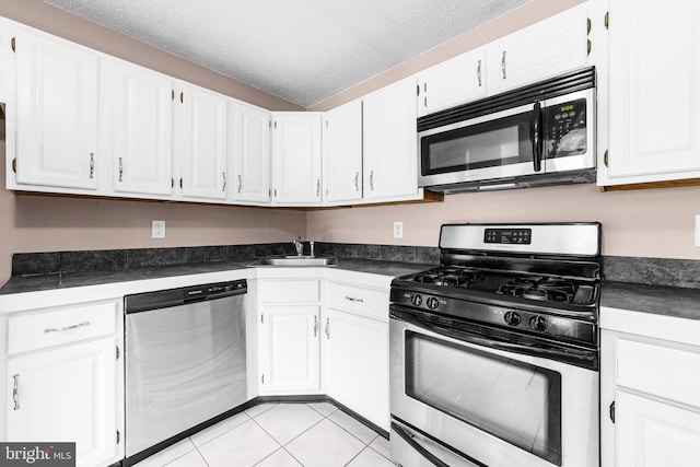 21 Fisher Dr, Franklin Park, NJ 08823 - kitchen with appliances with stainless steel finishes, dark countertops, white cabinets, a sink, and a textured ceiling