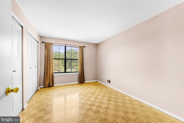 21 Fisher Dr, Franklin Park, NJ 08823 - unfurnished bedroom with multiple closets, baseboards, and a textured ceiling