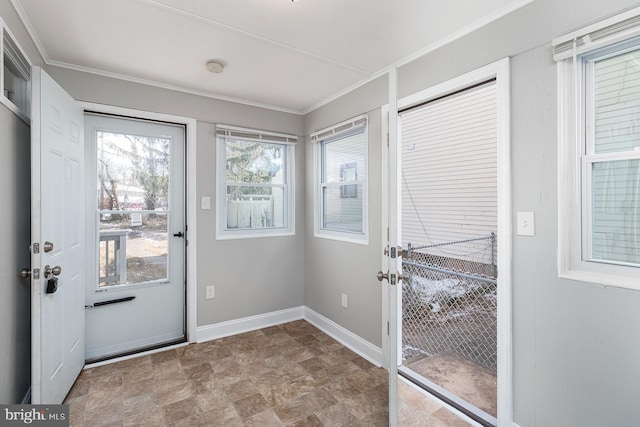 doorway to outside featuring stone finish flooring, baseboards, and crown molding