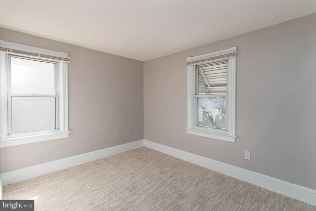 carpeted spare room with baseboards