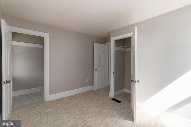 unfurnished bedroom with carpet, a closet, baseboards, and visible vents