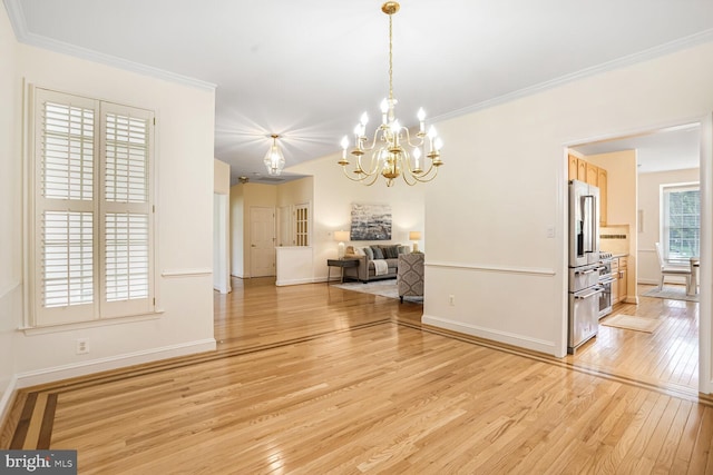 unfurnished dining area with light wood-style flooring, a chandelier, baseboards, and crown molding