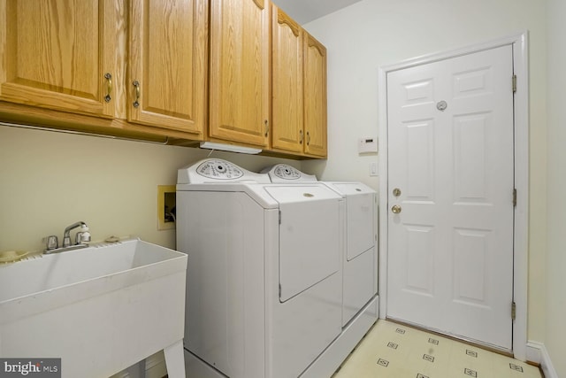 laundry area featuring washer and dryer, cabinet space, and light flooring