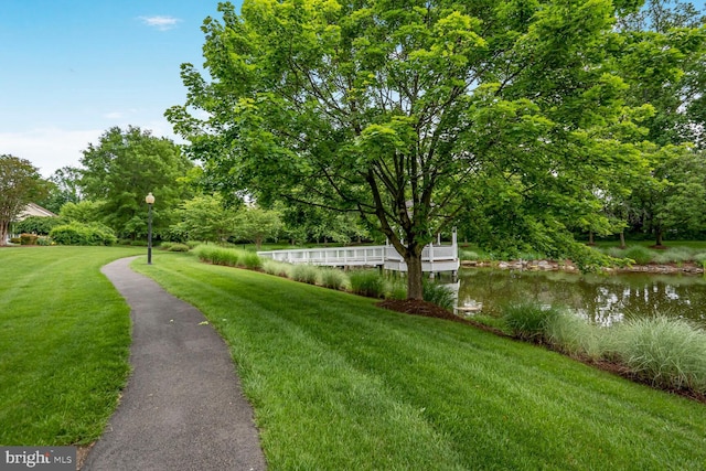 surrounding community featuring a yard, a water view, and view of scattered trees