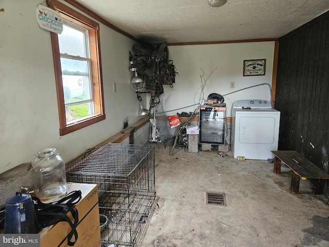 interior space featuring washer / dryer, a healthy amount of sunlight, crown molding, and concrete flooring