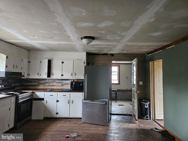 kitchen featuring range with electric cooktop, dark wood finished floors, dark countertops, freestanding refrigerator, and black microwave