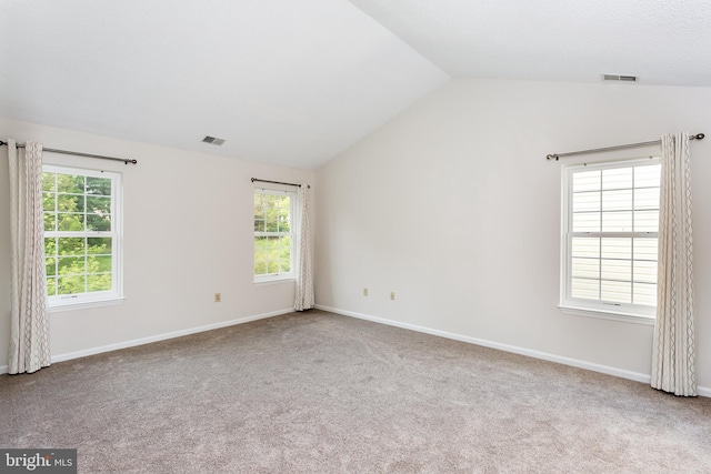 unfurnished room with visible vents, carpet, and lofted ceiling
