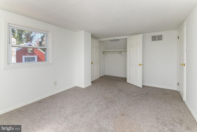 unfurnished bedroom with carpet floors, a closet, visible vents, and baseboards