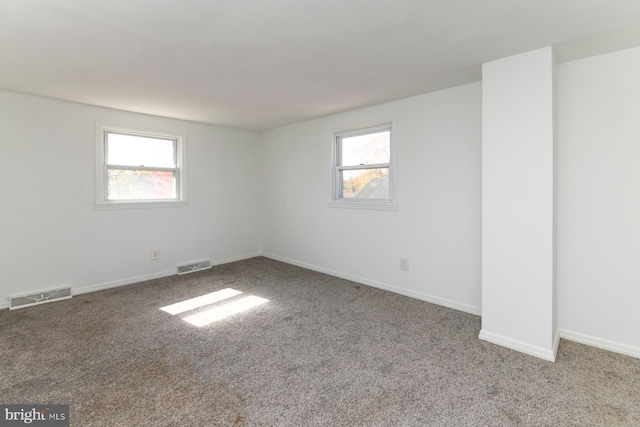 carpeted empty room with baseboards and visible vents