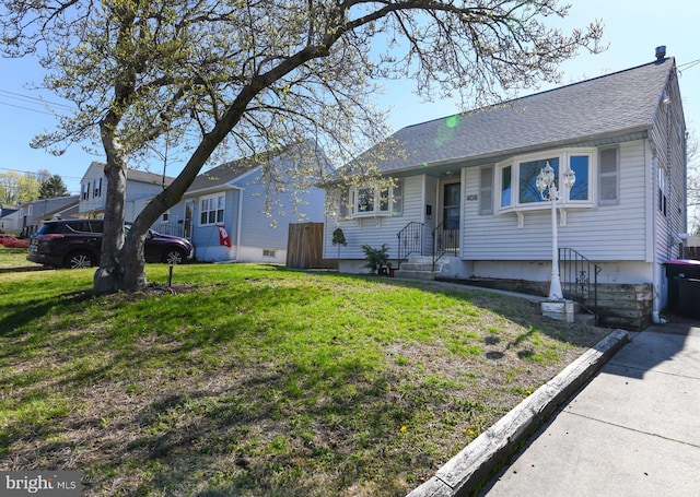 view of front of home with a front lawn and roof with shingles