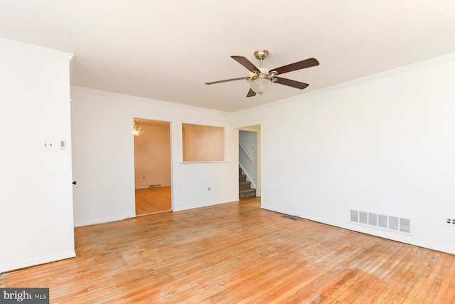 unfurnished room featuring ceiling fan, ornamental molding, wood finished floors, and visible vents